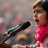 Malala Yousafzai speaking at a podium